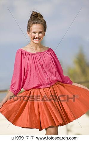 Stock Photo - Smiling girl wearing colorful skirt. Fotosearch