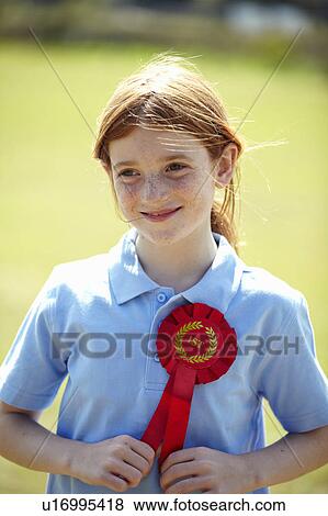 Stock Photo - Smiling girl wearing first place ribbon. Fotosearch