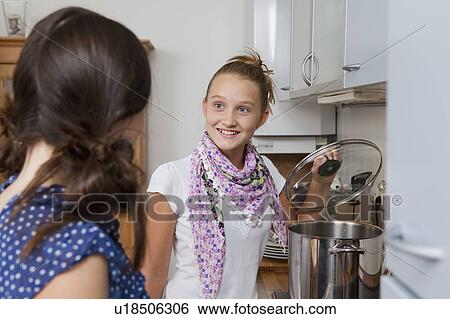 Smiling girls cooking in kitchen View Large Photo Image Stock Photograph - Smiling girls cooking in kitchen. Fotosearch
