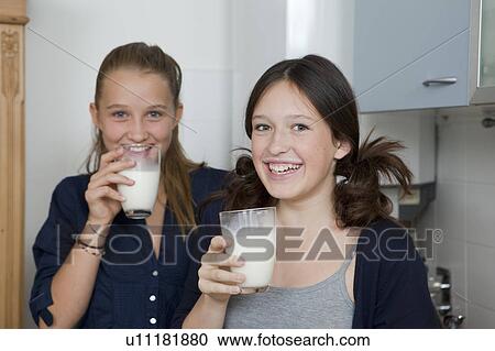 Smiling girls drinking milk in kitchen View Large Photo Image Stock Image - Smiling girls drinking milk in kitchen. Fotosearch