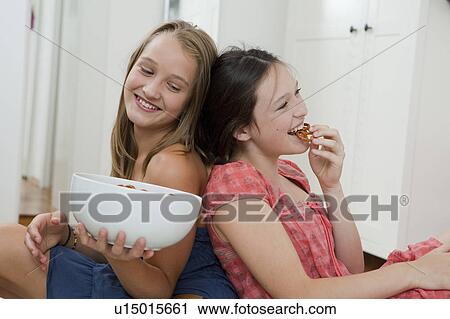 Smiling girls eating pretzels in bedroom View Large Photo Image Stock Image - Smiling girls eating pretzels in bedroom. Fotosearch