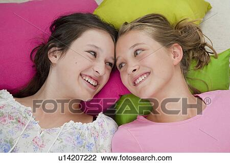 Smiling girls laying on pillows together View Large Photo Image Stock Image - Smiling girls laying on pillows together. Fotosearch