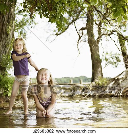 Smiling girls playing in lake View Large Photo Image Stock Image - Smiling girls playing in lake. Fotosearch