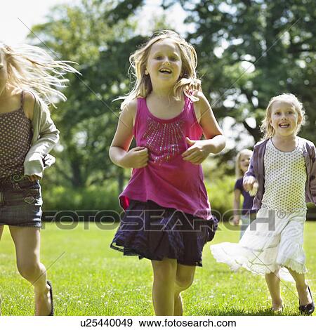 Smiling girls running in field View Large Photo Image Stock Photo - Smiling girls running in field. Fotosearch