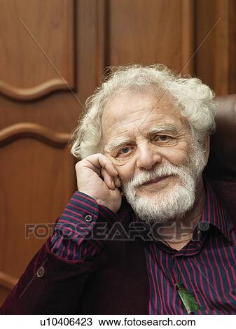 Smiling older man sitting in armchair View Large Photo Image Stock Image - Smiling older man sitting in armchair. Fotosearch