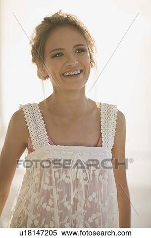 Stock Photography - Smiling teenage girl wearing sheer dress. Fotosearch