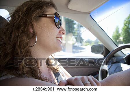 Smiling woman driving car View Large Photo Image Stock Image - Smiling woman driving car. Fotosearch