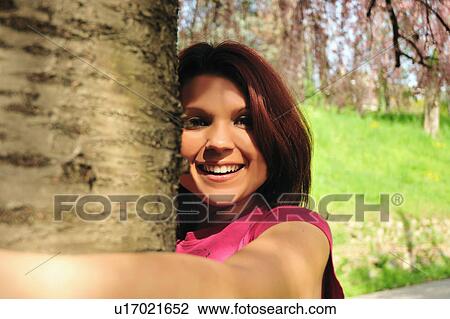 Smiling woman hugging tree View Large Photo Image Stock Image - Smiling woman hugging tree. Fotosearch