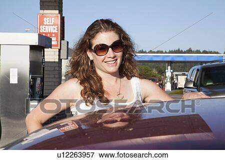 Smiling woman pumping gas at station View Large Photo Image Stock Photo - Smiling woman pumping gas at station. Fotosearch