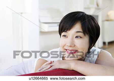 Smiling woman relaxing on sofa View Large Photo Image Stock Photography - Smiling woman relaxing on sofa. Fotosearch