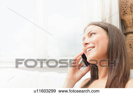 Stock Photo - Smiling woman talking on cell phone. Fotosearch