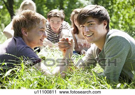 Teenage boys arm wrestling in grass View Large Photo Image Stock Image - Teenage boys arm wrestling in grass. Fotosearch