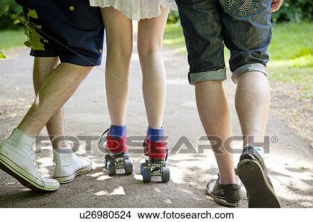 Picture - Teenage boys with roller skating girl. Fotosearch