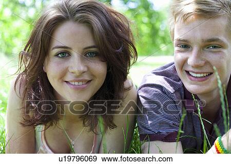 Stock Photo - Teenage couple laying in grass together. Fotosearch