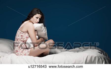 Teenage girl hugging pillow on bed View Large Photo Image Stock Image - Teenage girl hugging pillow on bed. Fotosearch