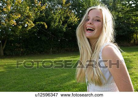 Stock Photo - Teenage girl laughing outdoors. Fotosearch