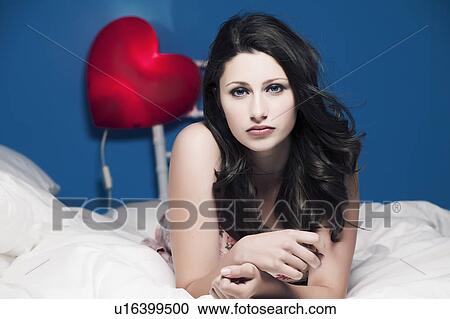Stock Image - Teenage girl laying on bed. Fotosearch