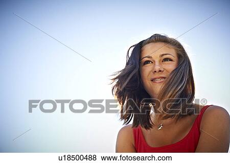 Teenage girl smiling against blue sky View Large Photo Image Stock Photo - Teenage girl smiling against blue sky. Fotosearch