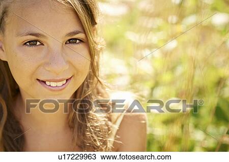 Teenage girl smiling in tall grass View Large Photo Image Stock Image - Teenage girl smiling in tall grass. Fotosearch