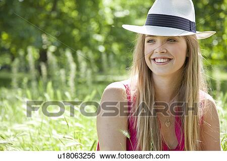 Teenage girl wearing hat in tall grass View Large Photo Image Stock Photograph - Teenage girl wearing hat in tall grass. Fotosearch
