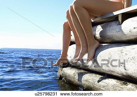 Teenage girls dangling legs over pier View Large Photo Image Stock Image - Teenage girls dangling legs over pier. Fotosearch