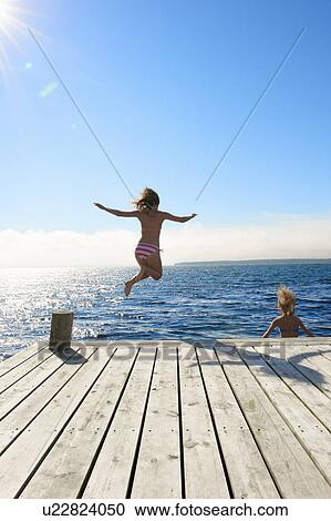 Teenage girls jumping into lake View Large Photo Image Stock Image - Teenage girls jumping into lake. Fotosearch
