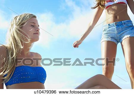 Stock Photograph - Teenage girls relaxing outdoors. Fotosearch