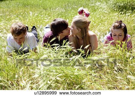 Stock Photo - Teenagers ignoring kissing friends. Fotosearch