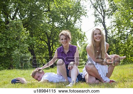 Stock Photography - Teenagers playing in grass in park. Fotosearch