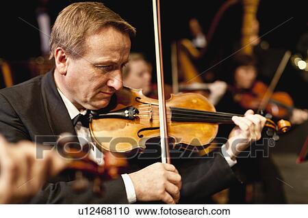 Stock Image - Violin player in orchestra. Fotosearch