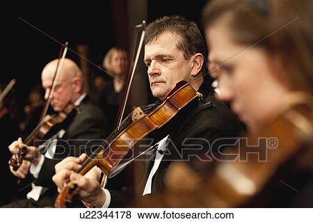 Stock Photo - Violin players in orchestra. Fotosearch