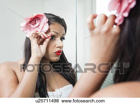 Woman adjusting her makeup in mirror View Large Photo Image Stock Photo - Woman adjusting her makeup in mirror. Fotosearch