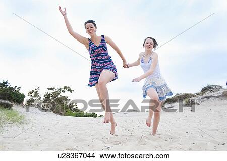 Woman and girl running on beach View Large Photo Image Picture - Woman and girl running on beach. Fotosearch