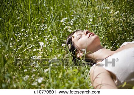 Stock Image - Woman asleep in tall grass. Fotosearch
