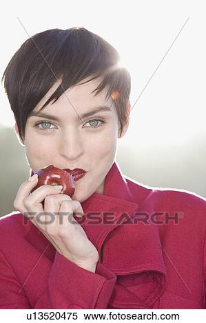 Woman eating apple outdoors View Large Photo Image Stock Photography - Woman eating apple outdoors. Fotosearch