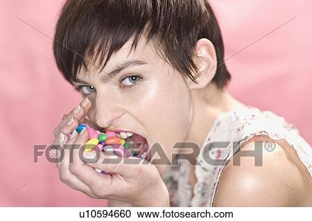 Woman eating handful of jellybeans View Large Photo Image Stock Image - Woman eating handful of jellybeans. Fotosearch