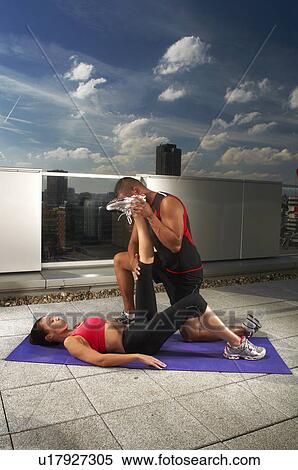 Woman exercising with trainer on rooftop View Large Photo Image Stock Photography - Woman exercising with trainer on rooftop. Fotosearch