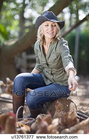 Woman feeding chickens on farm View Large Photo Image Stock Photo - Woman feeding chickens on farm. Fotosearch