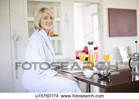 Woman in bathrobe at breakfast table View Large Photo Image Picture - Woman in bathrobe at breakfast table. Fotosearch