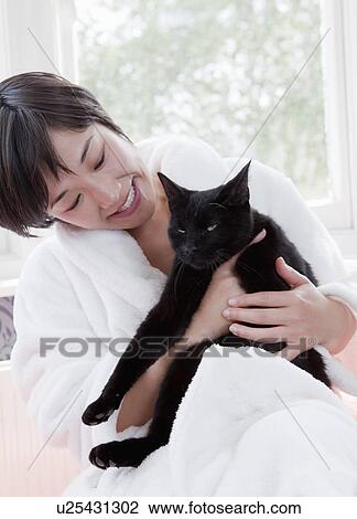 Woman in bathrobe holding cat View Large Photo Image Stock Image - Woman in bathrobe holding cat. Fotosearch