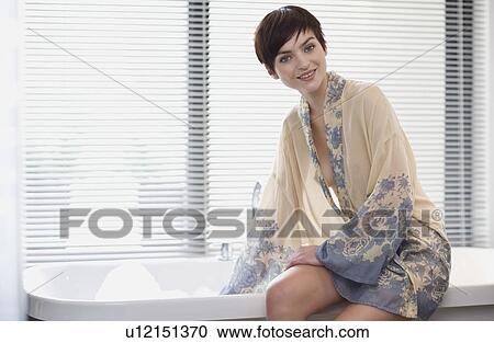 Woman in robe testing bathwater View Large Photo Image Stock Image - Woman in robe testing bathwater. Fotosearch