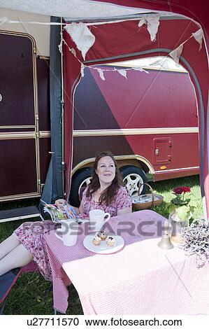 Woman reading magazine outside trailer View Large Photo Image Stock Image - Woman reading magazine outside trailer. Fotosearch