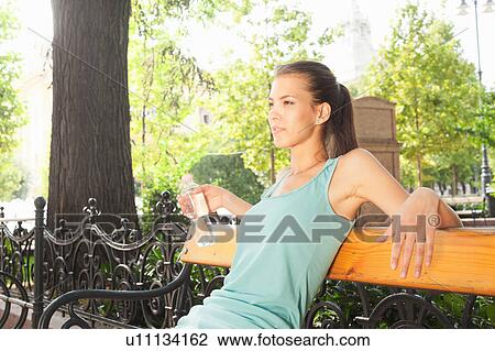 Woman relaxing on park bench View Large Photo Image Stock Image - Woman relaxing on park bench. Fotosearch