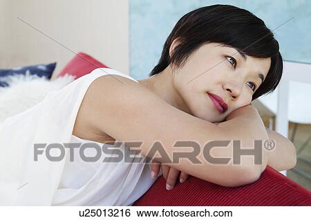 Woman relaxing on sofa View Large Photo Image Stock Photograph - Woman relaxing on sofa. Fotosearch