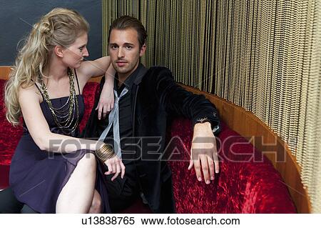 Stock Photography - Woman sitting on boyfriend's lap in bar. Fotosearch
