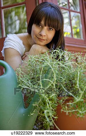 Woman sitting with plants on back porch View Large Photo Image Stock Photo - Woman sitting with plants on back porch. Fotosearch
