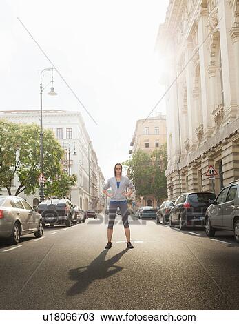 Stock Image - Woman standing on city street. Fotosearch