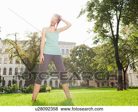 Stock Photo - Woman stretching in urban park. Fotosearch