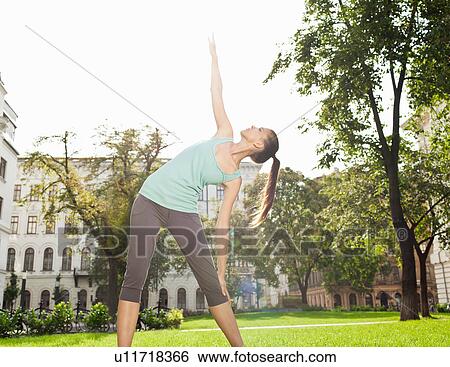Woman stretching in urban park View Large Photo Image Stock Photograph - Woman stretching in urban park. Fotosearch