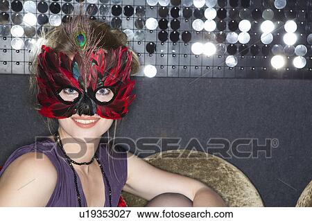 Woman wearing feather mask in bar View Large Photo Image Stock Photo - Woman wearing feather mask in bar. Fotosearch